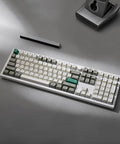 True Flex Full Size Custom Mechanical Keyboard With Hot Swappable Gateron Browns Qmk Via Firmware Bluetooth And 2.4Ghz Wireless Typing Rig RGB Backlit white keys on gray surface.