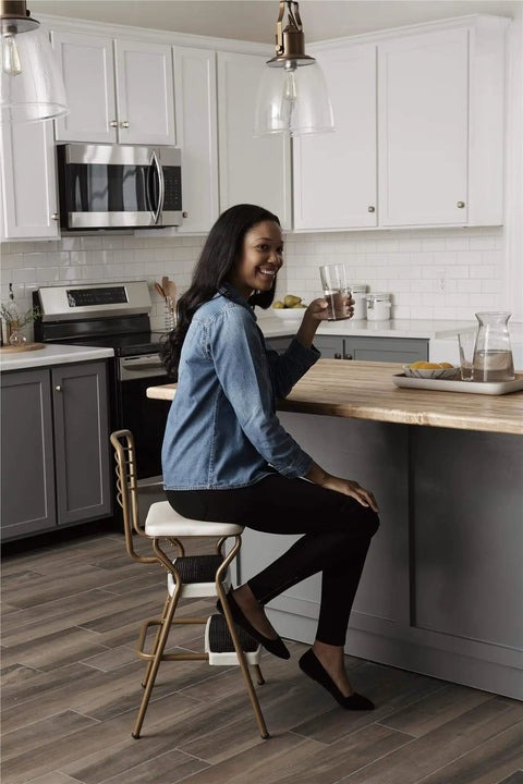 Woman sitting on Stylaire Retro Chair And Step Stool With Flip Up Seat Black Vinyl Upholstery Chrome Steel Frame