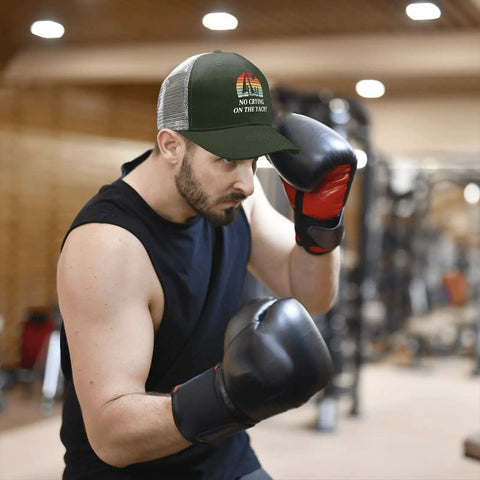 Man boxing in gym wearing Women's Lightweight Summer Trucker Cap Army Green Dope Everyday Wear Cotton Baseball Hat with Mesh Back