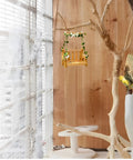 Set Of 2 Wooden Swing Bird Feeders For Outdoor Hangin With Metal Mesh Bottom in indoor garden setting with tree branches