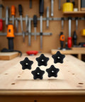 Five Pack Black Star Knobs For T Track Bolts And Feather Boards, 5/16-18 Female Thread, on a wooden workbench.
