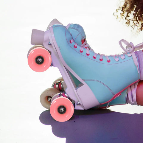 Close-up of blue quad skates with pink double row roller skate wheels with bearings 4 pack semi jelly outdoor wheels for inline and quad skates.