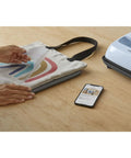 Front view of Cricut EasyPress Mat 12x12, heat-resistant protective mat beside Cricut EasyPress and a tote project