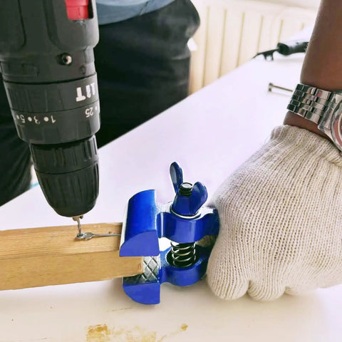 Person using Portable Hand Vise For DIY Projects With A 2 Inch Jaw Heavy Duty Handheld Vice For Cutting Sanding And Drilling Ideal For Home Workshop Lightweight And Compact At 6.5 Inches Weighs 1.4 Pounds Easy To Use And Carry on a wooden piece with a drill.