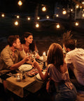 Lit Outdoor Edison Style String Lights 200Ft With 102 Shatterproof ST38 LED Bulbs illuminating a cozy outdoor dining area with friends