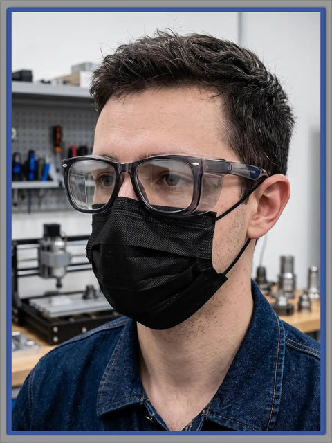 Close-up of a man wearing Slick Anti Fog Safety Glasses With Built In Side Shields, ANSI Z87.1 Certified, in workshop setting.