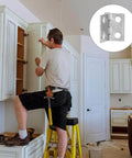 Man installing cabinet doors with Miniature Decorative Box Hinges Set 100 Pcs Silver 8x10mm With Nails visible in inset.