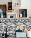 Grey Faux Brick Peel And Stick Wallpaper 17.7 X 393.7 Inches Removable Vinyl Wall Covering For Bathroom Or Living Space Oil And Water Resistant Easy DIY Decor For Quick Install shown in kitchen setting with wooden shelves and utensils.