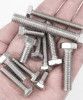 Stainless steel hex bolts with nuts held in hand; assorted lengths.