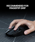 X2F Mini Fingertip Wireless Gaming Mouse Ultra Lightweight Low Latency Sensor Ergonomic Grip on a desk with a hand gripping it.