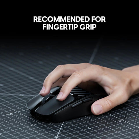 X2F Mini Fingertip Wireless Gaming Mouse Ultra Lightweight Low Latency Sensor Ergonomic Grip on a desk with a hand gripping it.
