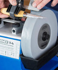 8 Inch SG-200 Grindstone 220-1000 Grit For T-3 And T-4 Sharpening Systems in use with a knife, showing fine surface finish on blade.