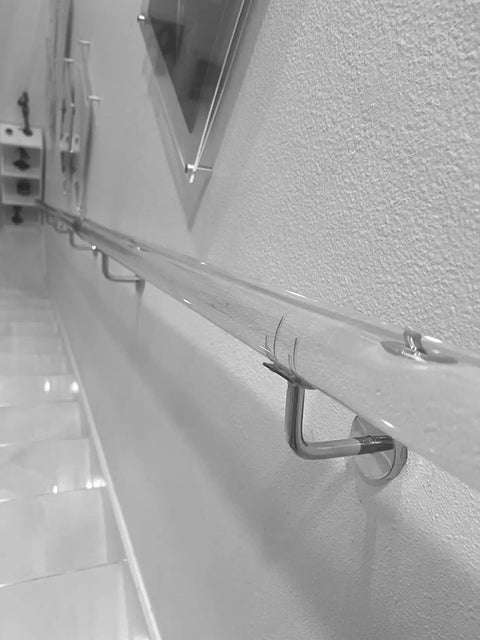 Get Ready To Level Up Your Space With This Epic Custom Acrylic Handrail Kit For Stairs Featuring Crystal Clear Lucite, Rock Solid Iron Brackets Supporting 440 Lbs Each, And A Grippy Non Slip Surface installed along a wall.
