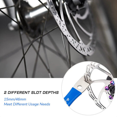 Bike Disc Rotor Truing Fork Tool Wrench with dual 15mm/46mm slot depths, in use on MTB brake rotor, ergonomic handle detail.
