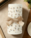 Rolled 4 Piece Bed Rail Covers For Teething With Breathable Cotton Gauze Teething Guard Set tied with ribbon, floral pattern.