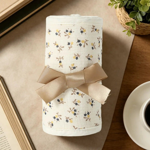 Rolled 4 Piece Bed Rail Covers For Teething With Breathable Cotton Gauze Teething Guard Set tied with ribbon, floral pattern.