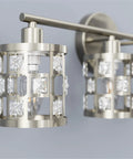 Close-up of brushed nickel 4 light bathroom vanity light fixture over mirror with cylinder crystal shade.