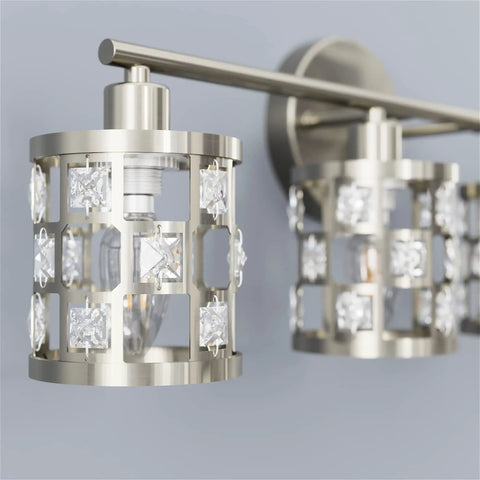 Close-up of brushed nickel 4 light bathroom vanity light fixture over mirror with cylinder crystal shade.
