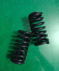 Built Different Heavy Duty Compression Springs Set Of Two High Carbon Steel Industrial Gear resting on green surface.