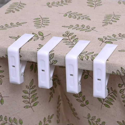 12 Pcs Plastic Spring Tablecloth Clips for Outdoor Tables No Slip Grip Easy Clamp Table Cloth Holders on leaf-patterned tablecloth.