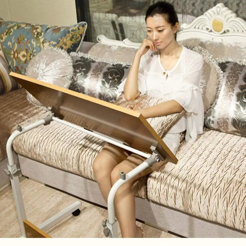 Sleek Rolling Laptop Desk With Locking Casters And Adjustable Tilt Tray Table For Home Office Bedroom Couch Computer Stand Fast Setup Portable Workspace Game Changer White 60X40 in use on a couch.