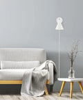Dope Lofty Chic Modern Matte White Wall Sconce with Brass Accent beside a gray sofa and table in a living room setup