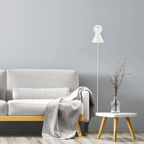 Dope Lofty Chic Modern Matte White Wall Sconce with Brass Accent beside a gray sofa and table in a living room setup