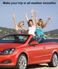 Three women enjoying a convertible ride on a sunny day along a scenic beach road.