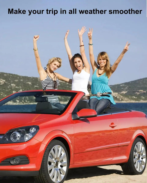 Three women enjoying a convertible ride on a sunny day along a scenic beach road.
