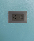 Top Shelf Six Gang Wall Outlet With Fast Charge Usb Ports And Polished Stainless Steel Faceplate, mounted on blue wall.