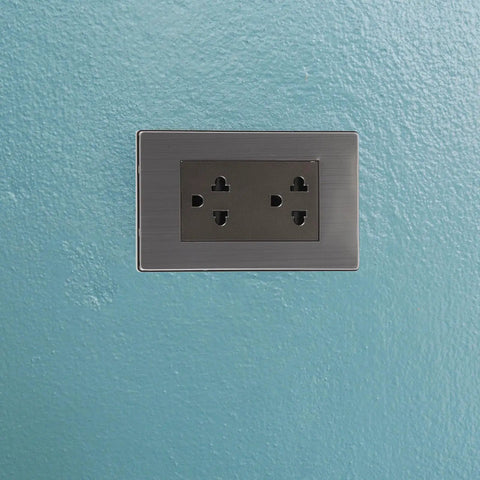 Top Shelf Six Gang Wall Outlet With Fast Charge Usb Ports And Polished Stainless Steel Faceplate, mounted on blue wall.