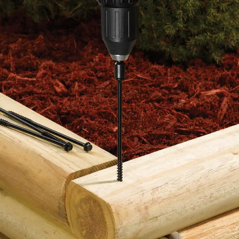 Drill driving TimberLOK Heavy Duty Wood Screw 6 Inch Black into wood, showcasing corrosion resistance and tapered head in garden setting.