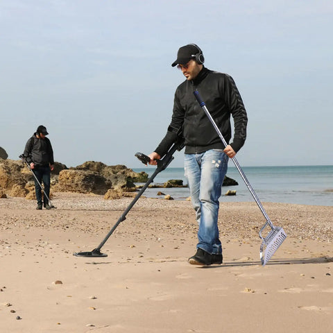 Two people using the Stainless Steel Sand Scoop For Metal Detecting Adjustable Handheld Treasure Hunter Shovel on a beach.