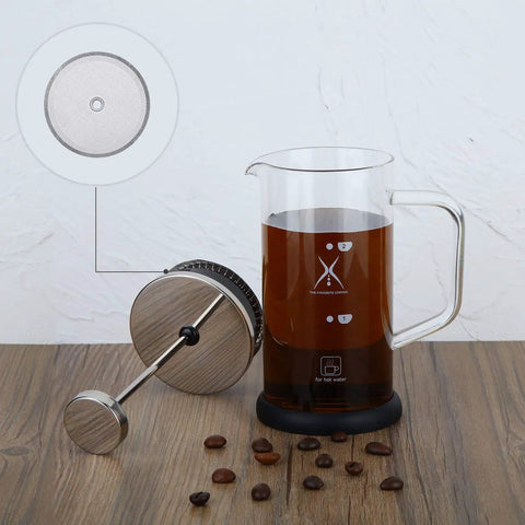 Six Pack French Press Replacement Filters 4 Inch Stainless Steel Mesh Screens next to glass coffee maker with coffee beans on wooden table.
