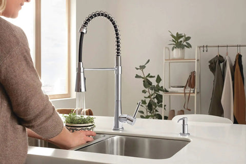 Precept Pull Down Kitchen Faucet With PowerInse Sprayer Chrome Finish in use at a modern kitchen sink setup.