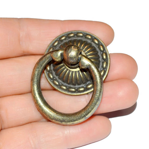Close-up of a vintage-style bronze drawer ring pull in hand, part of 8-Piece Bronze Drawer Ring Pulls Set With Screws For Dresser Cabinet Wardrobe.
