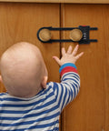 Four Pack Heavy Duty U Shape Cabinet Locks With Adjustable Password Latches Keep The Kiddos Out Of Drawers And Cupboards Adult Friendly No Fuss Safety Guards For Fridges And Closets Easy Install In Black on cabinets with a child reaching for them.