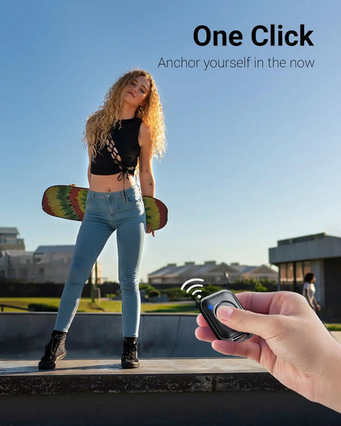 Person holding remote for 66 Inch Phone Tripod With Remote And Clamp Mount For iPhone And Android Extendable Stand, skateboarder in background.