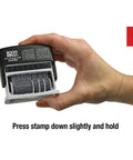 Slick Self Inking Micro Message Dater Stamp With Quick Flip Phrases For Office Organization showing usage with hand pressing down.