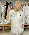 Woman wearing personalized embroidered lab coat with name in colorful font, white coat for doctors, professional fit