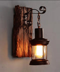 Top Shelf Rustic Wall Sconce Featuring Solid Wood Backplate And Vintage Industrial Metal Lantern Design with warm light.