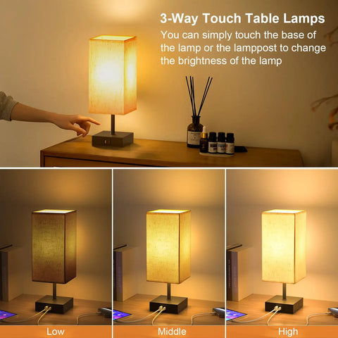 Touch Activated Bedside Lamp With USB C And USB A Charging Ports Three Way Dimmable Nightstand Light With Upgraded Fabric Shade LED Bulb Included Black Finish For Bedroom And Living Room on table showing dimming levels.