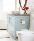 Bathroom with light blue vanity featuring polished nickel and golden champagne cabinet knobs, modern style design.