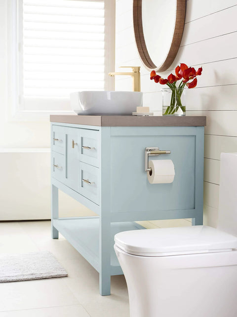 Bathroom with light blue vanity featuring polished nickel and golden champagne cabinet knobs, modern style design.