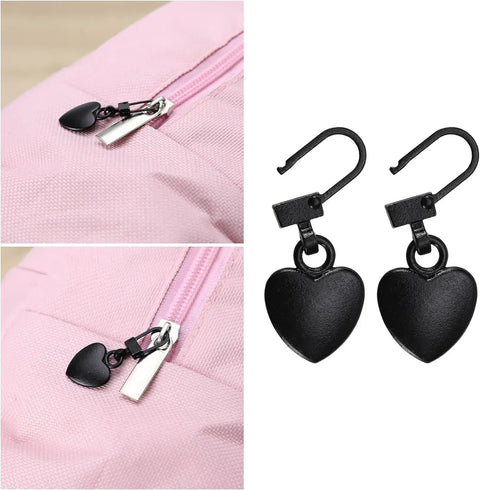 Two Piece Black Heart Shaped Zipper Pull Replacement Kit For Luggage Backpacks Jackets Coats Boots And Clothing Durable Metal Zipper Pulls With Universal Fit For Quick Slider Fix And Easy DIY Repair installed on a pink backpack.