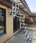 Rock Solid Electric Telescopic Ladder With Heavy Grip Handrails Wall Mounted Folding Attic Stairs That Tuck Away Fast For Clutter Free Layouts And No Sweat Daily Use Indoors Or Outdoors Right Now In Sleek Matte Black Finishing Touch installed on exterior wall with open steps visible.
