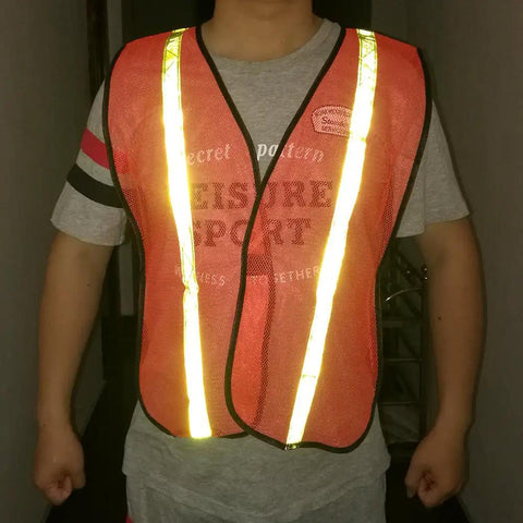 Person wearing High Visibility Reflective Safety Vests 10 Pack, Adjustable Lightweight Neon Orange with reflective strips for night safety.