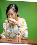 Person enjoying a drink with a Copper Turkish Coffee Pot With Wooden Handle For Quick Brew And Multi Purpose Beverage Kettle No Fuss Pour