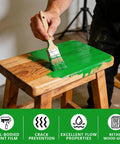 Applying No Sweat Heavy Duty Green Wood Stain And Deck Sealant For Exterior Fences Porch Boards And Patio Decks Zero VOC on wooden stool.