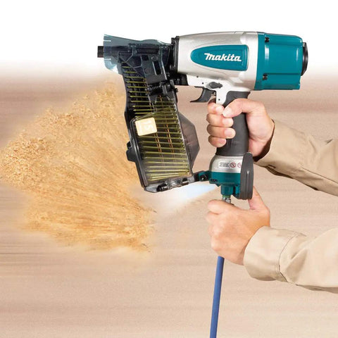 Premium Pneumatic 15 Degree Siding Coil Nailer With Tool-Less Depth Adjustment And Nine Detents in use, showing spray effect.